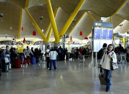 Viajeros esperan su turno para acceder a los mostradores en la Terminal 4 del aeropuerto de Barajas