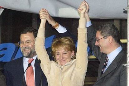 Mariano Rajoy y Alberto Ruiz-Gallardón flanquean a Esperanza Aguirre la noche de su victoria electoral en Madrid.