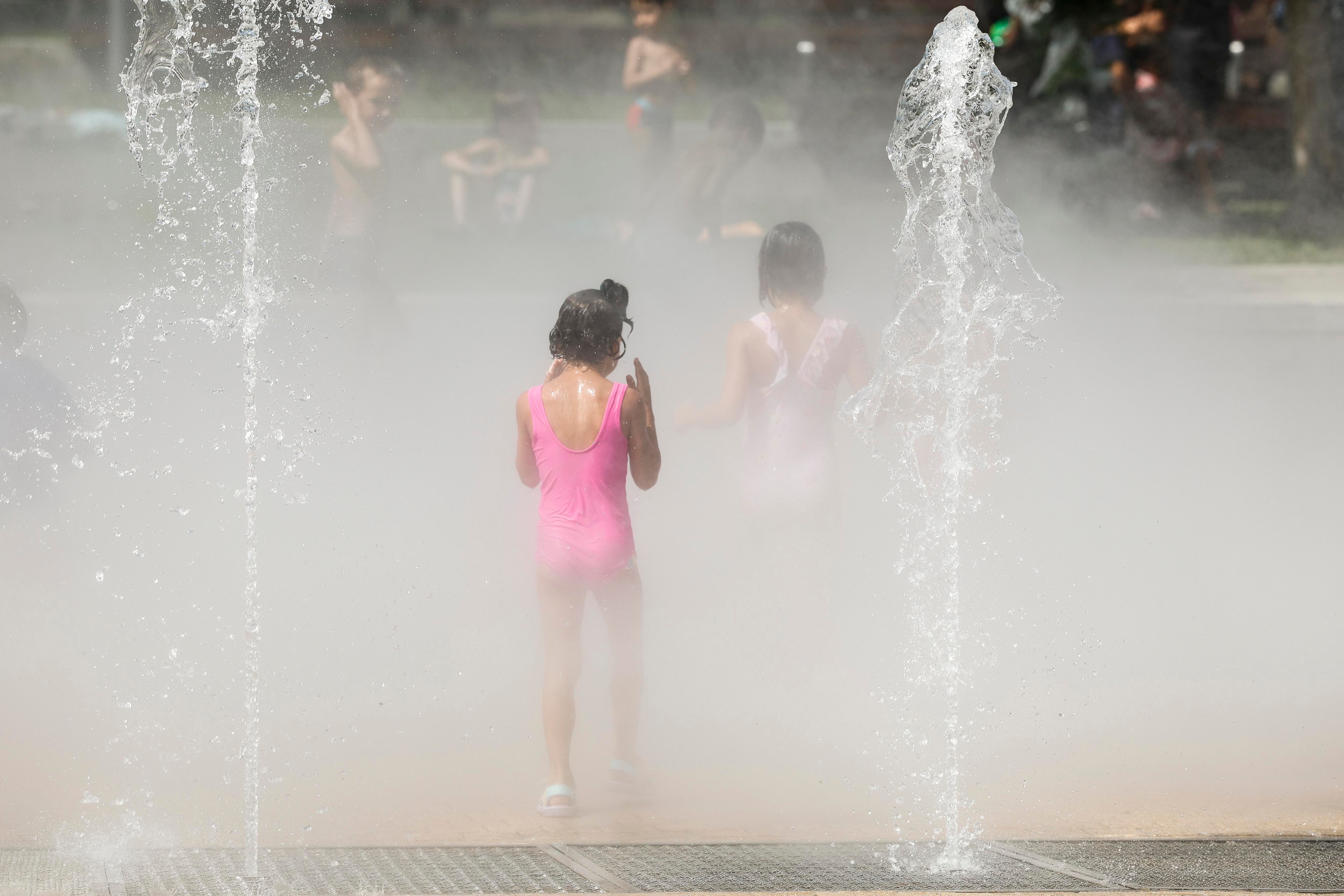 Varios niños se refrescan en una fuente de Bilbao, este miércoles, en una jornada en la que El Gobierno Vasco ha elevado a rojo el nivel de alerta por temperaturas extremas.