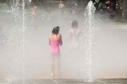 Varios niños se refrescan en una fuente de Bilbao, este miércoles, en una jornada en la que El Gobierno Vasco ha elevado a rojo el nivel de alerta por temperaturas extremas.