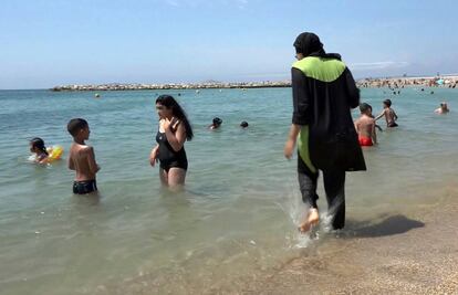 Una mujer entra en el mar con el vestido tradicional musulmán en Marsella.