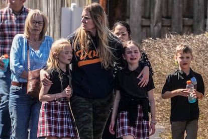 Children and a woman depart the reunification center at the Woodmont Baptist church after a school shooting, Monday, March 27, 2023, in Nashville, Tennessee