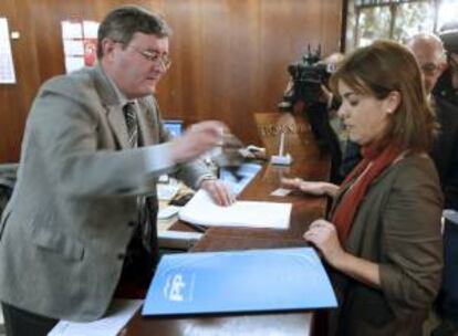 Soraya Sáenz de Santamaría, acompañada por Cristóbal Montoro (detrás), presentando en el registro del Tribunal Constitucional un recurso contra distintos apartados de los presupuestos generales del Estado de 2009. EFE/Archivo