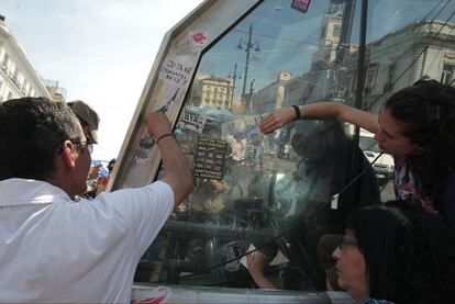 Varias personas quitan las pegatinas y los carteles de la estación de la Puerta del Sol.