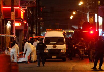 Un grupo de forenses levanta los cuerpos de los asesinados en el centro de Monterrey.