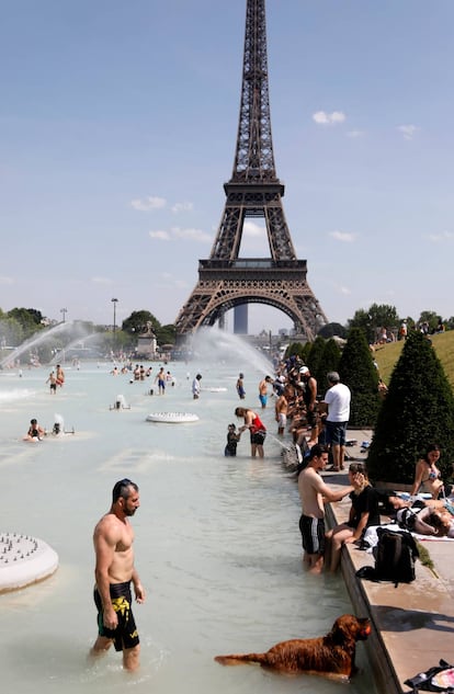 La gente se baña en las fuentes de Trocadero, frente a la Torre Eiffel de París, este martes.