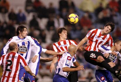 El defensa del Athletic Mikel San José remata un balón en presencia de Toquero, Llorente  y varios  jugadores del Deportivo.