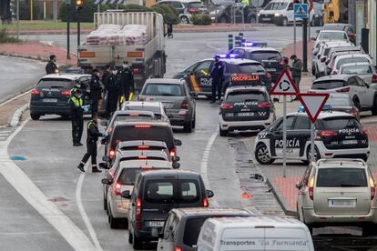 Agentes de la policía reparten mascarillas a los conductores en la entrada del polígono industrial Oeste de Murcia.