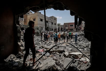 Palestinos inspeccionan una casa destruida por los ataques aéreos israelíes en el sur de la ciudad de Gaza.