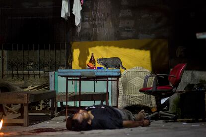 Un hombre yace muerto 
en la puerta de su casa, 
en Ciudad Quezón. 
Fue asesinado mientras bebía en la calle.