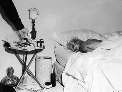 Imagen inédita del cadáver de Marilyn Monroe en el dormitorio de su casa. Un policía, probablemente el sargento Jack Clemmons, señala las pastillas que provocaron la muerte de la actriz.