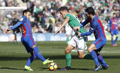 El delantero del Real Betis, Alex Alegría (centro), se lleva la pelota ante Arda Turan (d) y Neymar, del Barcelona.