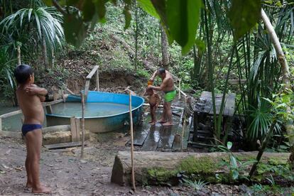 Indígenas da aldeia Dois irmãos tomam banho em um olho d'água, que se tornou uma represa improvisada depois que eles retiraram uma caixa d'água de uma obra que não funcionava mais.