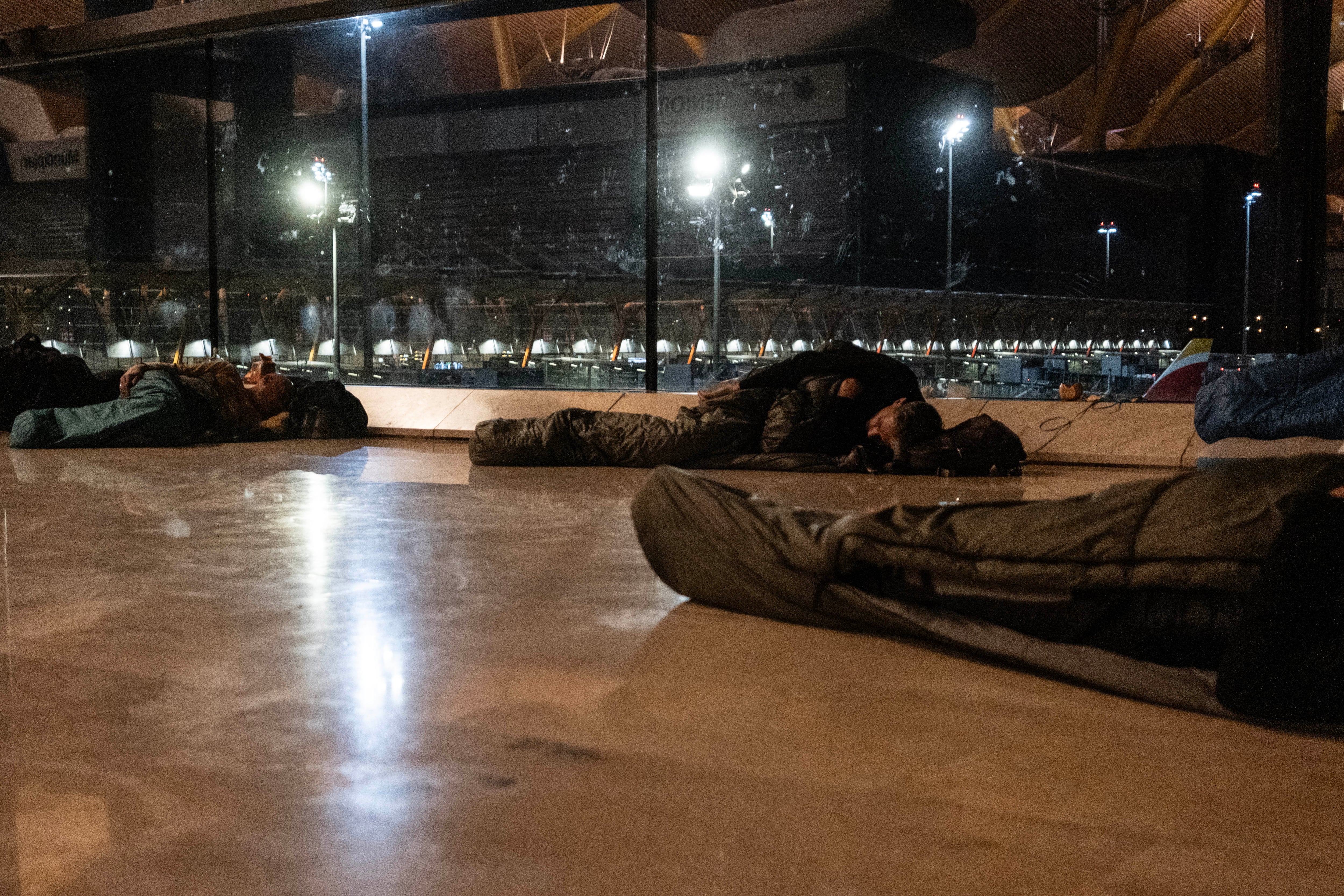 Personas durmiendo en un ala de la T4 de Barajas durante la madrugada del lunes. 