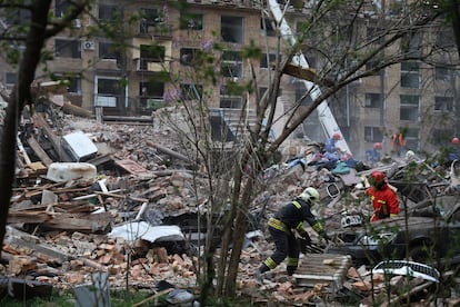 Los equipos de rescate buscan víctimas entre los escombros de un edificio alcanzado este jueves por un misil ruso en Kiev.