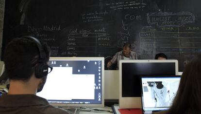 Estudiantes en un aula de 'coworking' con sus ordenadores.
