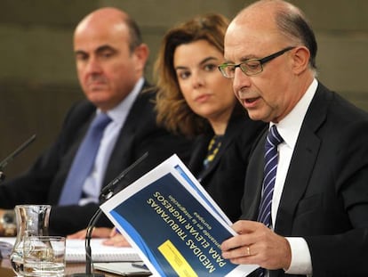 El ministro de Hacienda, Cristóbal Montoro, la vicepresidenta Soraya Sáenz de Santamaría, y el ministro de Economía, Luis De Guindos.