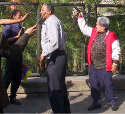 Un hombre armado con una pistola amenaza a los partidarios de la huelga general en Caracas.