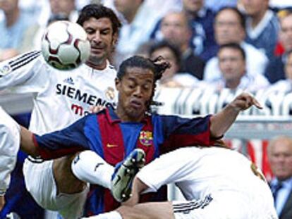 Ronaldinho intenta un control entre Figo y Michel Salgado.