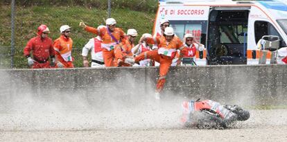 Los comisarios saltan a la pista para atender a Pirro, su moto todavía rueda por la grava.