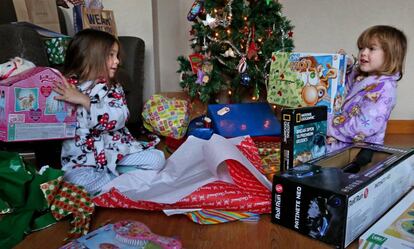 Dos ni&ntilde;as abriendo ayer sus regalos de Reyes, en Madrid.