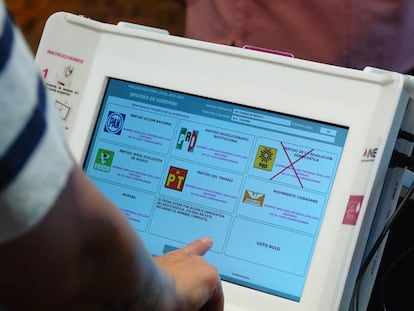 Una persona explora el funcionamiento de las urnas electrónicas que se usarán en las casillas especiales en las próximas elecciones.