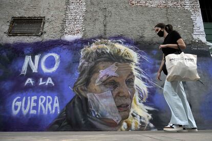 Una mujer pasa junto al graffiti "No a la guerra" del muralista Maximiliano Bagnasco, en Buenos Aires, este mes de marzo.