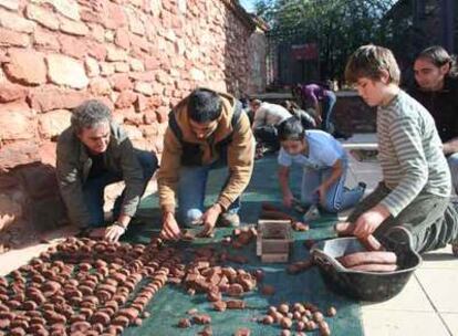 Participantes del taller de <i>nendo dango</i> plantan semillas envueltas en bolas de arcilla.