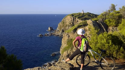 Una ciclista contempla el mar en la isla de Porquerolles, en la  Costa Azul francesa.