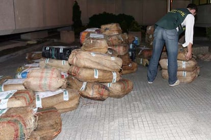 Un guardia civil apila los fardos de cocaína aprehendidos ayer en el municipio de Zas (A Coruña).