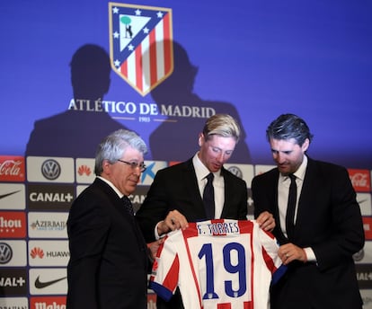 El presidente del Atlético de Madrid, Enrique Cerezo (i), Fernando Torres y José Luis Pérez Caminero (d) muestran la camiseta con el número 19, durante la presentación de Fernando Torres como jugador del Atlético de Madrid en el estadio Vicente Calderón en 2015.