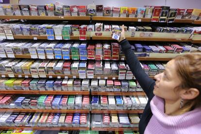 Una dependienta de un estanco muestra una cajetilla de tabaco, en Madrid.