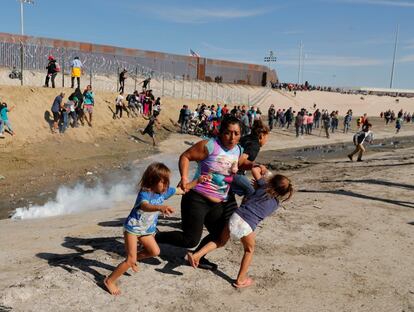 Una mujer, con sus dos hijas, huye de los gases lacrimógenos lanzados por la patrulla fronteriza estadounidense en Tijuana (México), cuando intentaban cruzar la frontera hacia Estados Unidos, el 25 de noviembre de 2018. Hasta el mes de noviembre, 5.000 migrantes centroamericanos habían llegado a la ciudad de Tijuana, en una caravana que inició desde San Pedro Sula (Honduras) con 800 personas, el 13 de octubre. Como parte del nuevo plan Marshall para Centroamérica, el Gobierno mexicano anunció que invertirá 25.000 millones de dólares (casi 22.000 millones de euros) en los próximos cinco años en el sur del país y EE UU destinará otros 5.800 millones de dólares (5.100 millones de euros) para la gobernanza de Centroamérica.