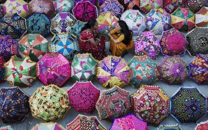 Dos mujeres venden sombrillas multicolores a los turistas en Jaipur, la ciudad rosa, en India.