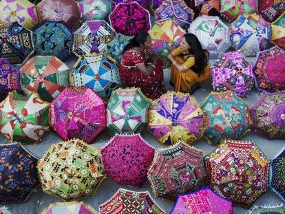 Dos mujeres venden sombrillas multicolores a los turistas en Jaipur, la ciudad rosa, en India.  