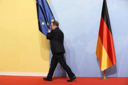 Un trabajador retira una bandera europea de un salón durante el G-20.