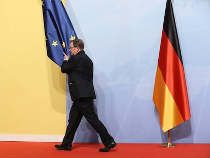 Un trabajador retira una bandera europea de un sal&oacute;n durante el G-20.