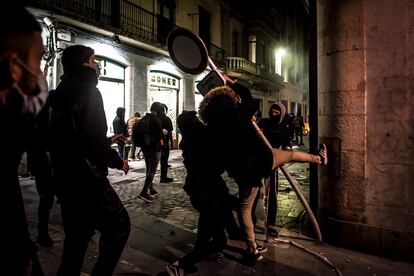 Varios manifestantes arrancan una señal de tráfico en Girona con la intención de utilizarla como ariete en sus protestas contra los Mossos tras la encarcelación de Pablo Hasél.