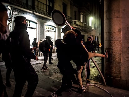 Varios manifestantes arrancan una señal de tráfico en Girona con la intención de utilizarla como ariete en sus protestas contra los Mossos tras la encarcelación de Pablo Hasél.