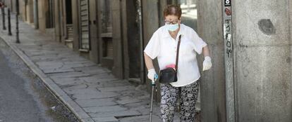 Una persona mayor camina por una calle de Madrid.