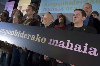 Arnaldo Otegi (a la derecha), junto al sacerdote irlandés Alec Reid, en el acto de ayer en Pamplona.