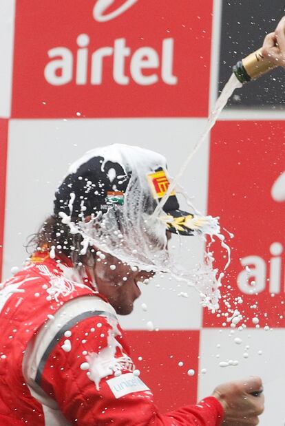 Fernando Alonso, tercero, es bañado durante la celebración final.