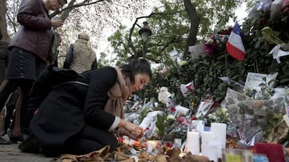Una dona encén una espelma davant de la sala Bataclan, aquest dimarts a París.