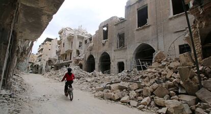 Un ni&ntilde;o monta en bicicleta, este jueves en Alepo (Siria).