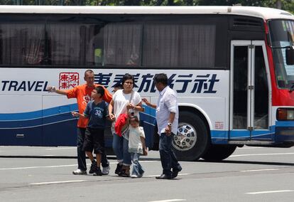 Dos negociadores de la policía hablan con los turistas extranjeros procedentes de Hong Kong nada más ser puestos en libertad. El ex agente dejó en libertad a los menores que había en el vehículo.