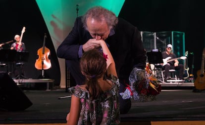 El artista agradeciendo el ramo de flores que le ofrece una niña durante su concierto en el Palau de les Arts.