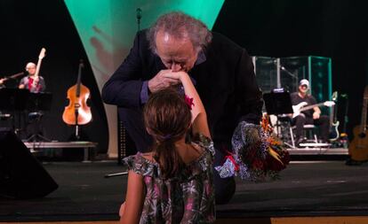 El artista agradeciendo el ramo de flores que le ofrece una niña durante su concierto en el Palau de les Arts.