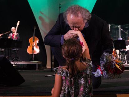 El artista agradeciendo el ramo de flores que le ofrece una niña durante su concierto en el Palau de les Arts.