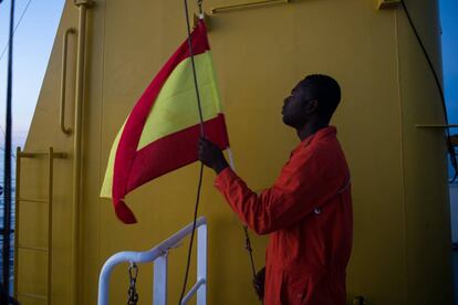 Un marinero del 'Aquarius' iza la bandera de España horas antes de llegar a Valencia.