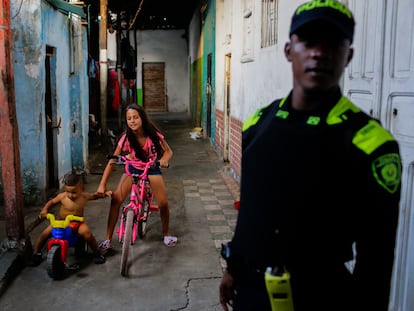 Children play and a police officer stands guard in the neighborhood of La Inmaculada.